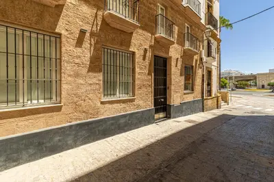 an empty street in front of a brick building at Allo Apartments San Roque 1ºA in Cádiz