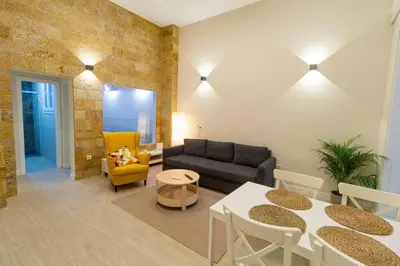 a living room with a couch and a table and chairs at SH Casa Candelaria. Apartamento en el centro. in Cádiz