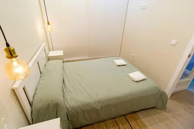 a small bedroom with a bed with two towels on it at SH Casa Candelaria. Apartamento en el centro. in Cádiz