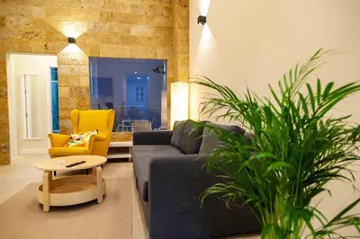a living room with a blue couch and a yellow chair at SH Casa Candelaria. Apartamento en el centro. in Cádiz