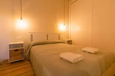 a bedroom with a bed with two towels on it at SH Casa Candelaria. Apartamento en el centro. in Cádiz
