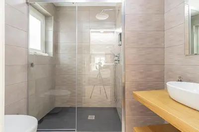 a bathroom with a glass shower and a sink at Allo Apartments San Roque Bajo B in Cádiz