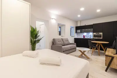 a bedroom with a bed and a living room at Allo Apartments San Roque Bajo C in Cádiz