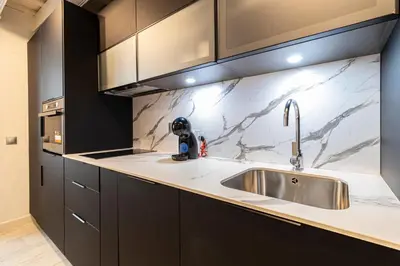 a kitchen with a stainless steel sink and black cabinets at Allo Apartments San Roque 1ºB in Cádiz