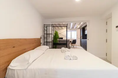 a bedroom with a large white bed with white shoes on it at Allo Apartments San Roque 1ºB in Cádiz