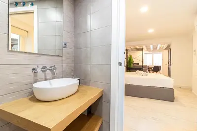 a bathroom with a sink and a bedroom at Allo Apartments San Roque 1ºB in Cádiz