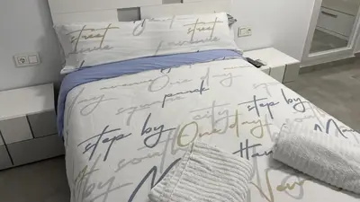 a bedroom with a bed with writing on it at Piso de lujo en primera linea de playa y garaje in Cádiz