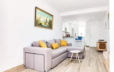 a living room with a gray couch and yellow pillows at 3 Bedroom Amazing Apartment In Cadiz in Cádiz