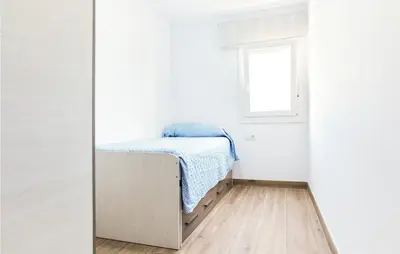 a small bedroom with a bed in a white room at 3 Bedroom Amazing Apartment In Cadiz in Cádiz