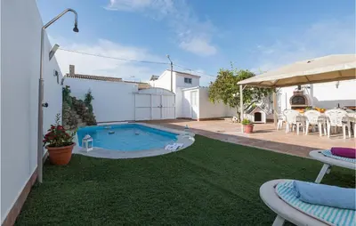 a backyard with a pool and a table and chairs at Stunning Home In San Jose Del Valle in San Jose del Valle