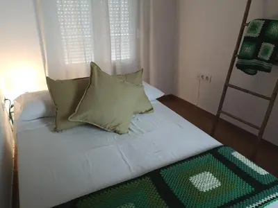 a bed with pillows and a ladder in a room at La Casita del Arte in Cádiz