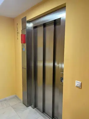 a row of metal elevators in a building at Colón Corazón de Cádiz con Ascensor Grupo AC Gestion in Cádiz