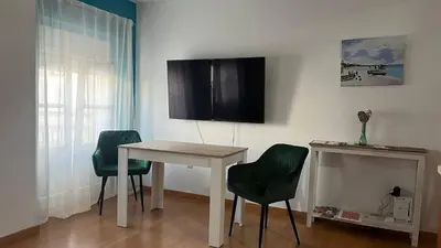a room with a table and two chairs and a television at Colón Corazón de Cádiz con Ascensor Grupo AC Gestion in Cádiz