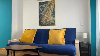 a blue couch with yellow pillows in a living room at Colón Corazón de Cádiz con Ascensor Grupo AC Gestion in Cádiz