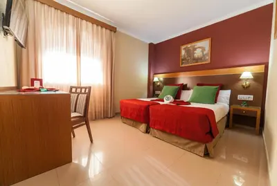 a hotel room with a bed and a desk at Hotel Regio 2 in Cádiz