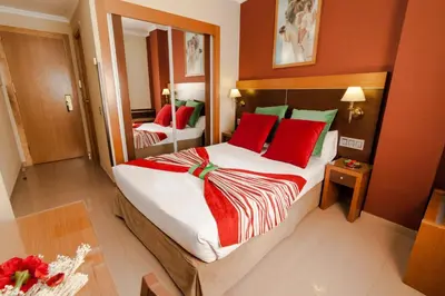 a bedroom with a large bed with red pillows at Hotel Regio 2 in Cádiz