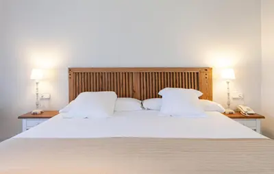 a large bed with white sheets and pillows at Playa de la Luz in Rota