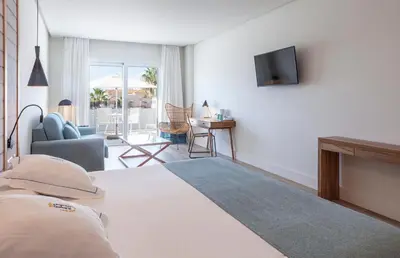 a bedroom with a bed and a couch and a television at Playa de la Luz in Rota