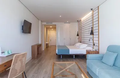a room with a bed and a couch and a table at Playa de la Luz in Rota