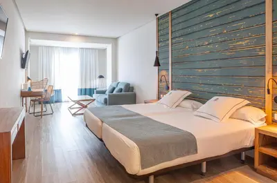 a bedroom with a large bed with a large wooden headboard at Playa de la Luz in Rota