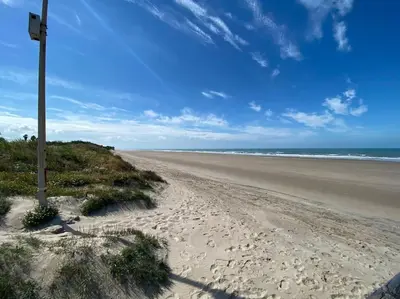 a sandy beach with a pole in the sand at Villa palacio Playa y piscina Grupo AC Gestion in Cádiz