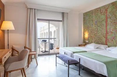a hotel room with two beds and a balcony at Hotel Duque de Najera in Rota