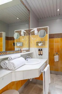a bathroom with a sink and a mirror and towels at Hotel Duque de Najera in Rota