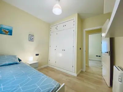 a bedroom with a blue bed and a large closet at Bright Beach House Grupo AC Gestion in Cádiz