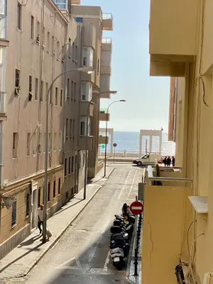 an empty city street with buildings and the ocean at Bright Beach House Grupo AC Gestion in Cádiz