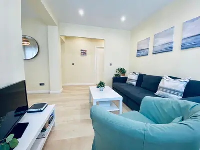 a living room with a blue couch and a tv at Bright Beach House Grupo AC Gestion in Cádiz