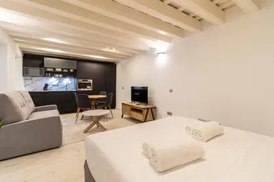 a bedroom with a bed and a couch and a kitchen at Allo Apartments San Roque 1ºC in Cádiz