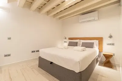 a bedroom with a large bed with white sheets at Allo Apartments San Roque 1ºC in Cádiz