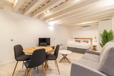 a living room with a table and chairs and a bed at Allo Apartments San Roque 1ºC in Cádiz