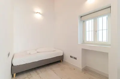a white bedroom with a bed and a window at Allo Apartments San Roque 2ºA in Cádiz
