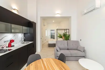 a kitchen and living room with a table and a couch at Allo Apartments San Roque 2ºB in Cádiz
