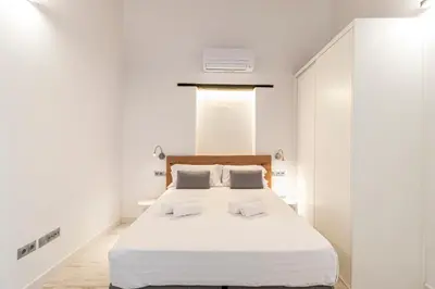 a bedroom with a large white bed with two pillows at Allo Apartments San Roque 2ºC in Cádiz