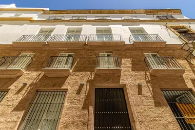 a tall brick building with windows and balconies at Allo Apartments San Roque 3ºB in Cádiz