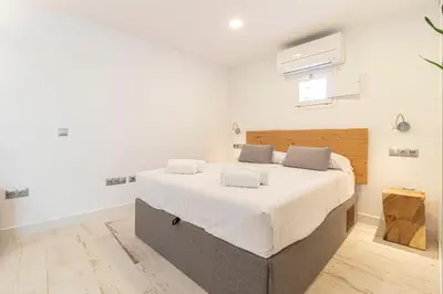 a bedroom with a large bed with white sheets at Allo Apartments San Roque 3ºC in Cádiz