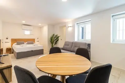 a living room with a table and a bed at Allo Apartments San Roque 3ºC in Cádiz