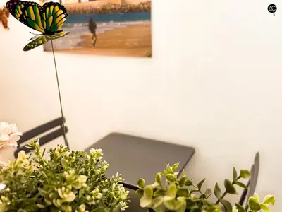 a butterfly sitting on a table with flowers and a butterfly on it at Casita del Mentidero Grupo AC Gestion in Cádiz