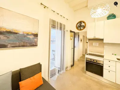 a kitchen with a couch and a clock on a wall at Casita del Mentidero Grupo AC Gestion in Cádiz