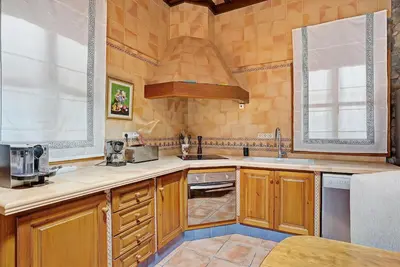 a large kitchen with wooden cabinets and a sink at CASA DAGO in Chiclana de la Frontera