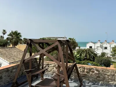 a wooden chair sitting on top of a balcony at CASA DAGO in Chiclana de la Frontera