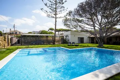 a swimming pool in the yard of a house at CASA DAGO in Chiclana de la Frontera