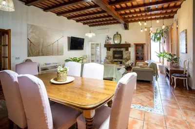 a living room with a wooden table and chairs at CASA DAGO in Chiclana de la Frontera
