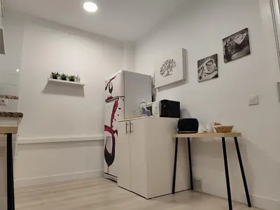 a white refrigerator in a kitchen with a table at Apartamento Catamarán in El Puerto de Santa María