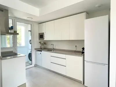 a white kitchen with white cabinets and a sink at Apartamento en Costa Ballena in Chipiona