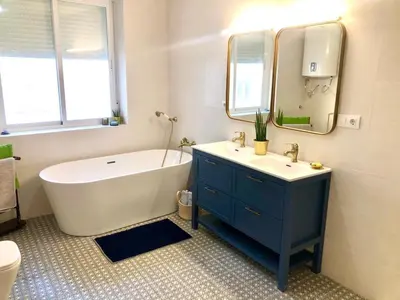a bathroom with a tub and a sink and a mirror at Gran casa señorial de 300m en centro histórico in El Puerto de Santa María