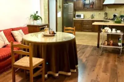 a living room with a table and a kitchen at Gran casa señorial de 300m en centro histórico in El Puerto de Santa María