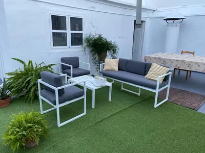 a patio with two blue chairs and a table at Gran casa señorial de 300m en centro histórico in El Puerto de Santa María